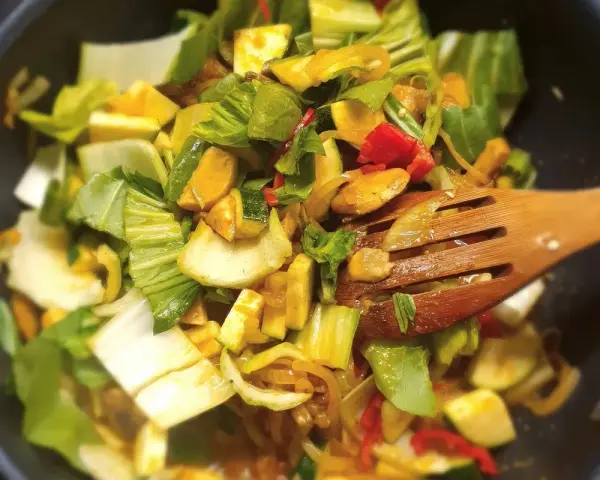Kolorowe warzywa, w tym kapusta pak choi, smażone na patelni. Idealne do szybkich i zdrowych dań, inspiracja do kapusta pak choi przepisy.