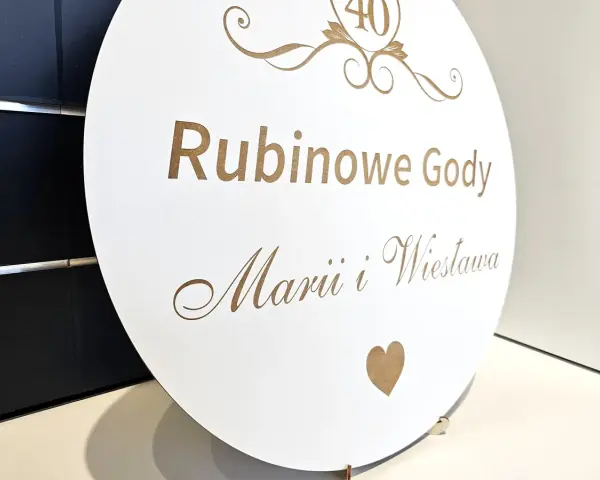 Okrągła tablica z napisem "Rubinowe Gody Marii i Wiesława" i cyfrą "40" na górze.
