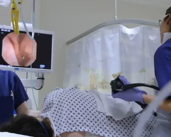 Lekarze przeprowadzają kolonoskopię, obserwując obraz z wnętrza jelita na monitorze.