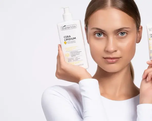 Kobieta prezentuje emulsję i krem Bielenda Cera Lipidum. Produkty z linii linoderm odbudowują barierę lipidową skóry.