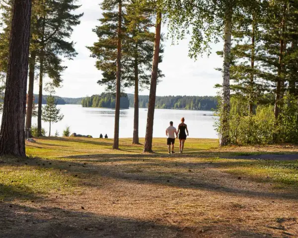 Ett par promenerar hand i hand vid en sjö, en idyllisk plats som påminner om det första camp ansia.