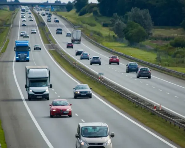 Ruch na autostradzie, gdzie samochody jadą różnymi pasami. Pytanie, czy na autostradzie można wyprzedzać z prawej strony, jest kluczowe dla bezpieczeństwa.