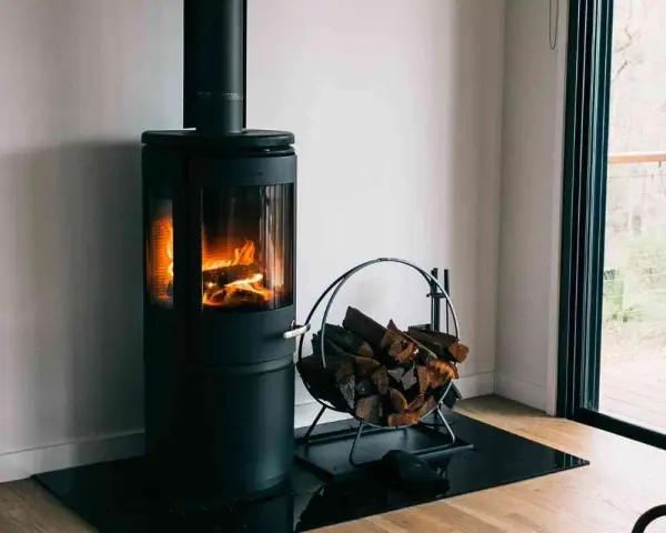 Poêle à bois moderne avec flammes vives et bûches. Une question se pose : peut-on installer un poêle à granule soi même ?