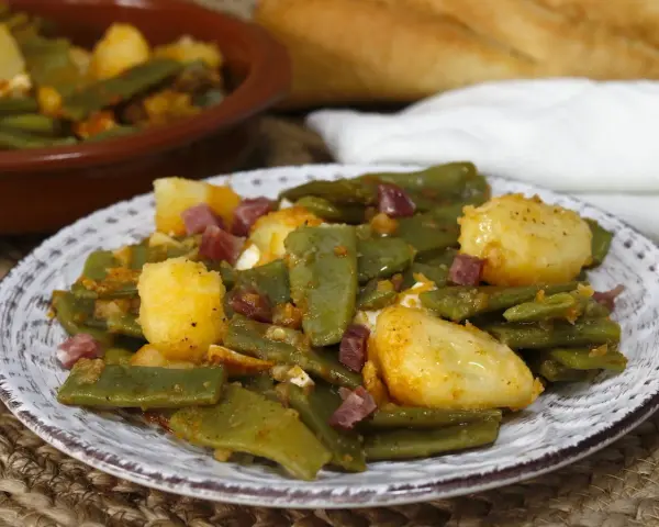 Plato de judías verdes con jamón y patatas, un clásico casero.