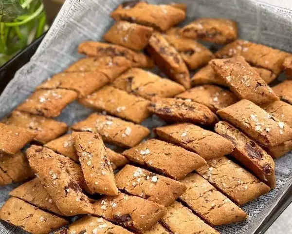 En hög med gyllene kolakakor med chokladbitar och flingsalt. Perfekt för ett enkelt kolakakor recept.