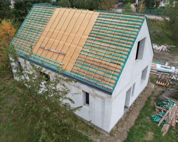 Budowa projektu domu 30m2 w trakcie. Widoczna konstrukcja dachu z łatami.