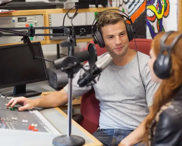 Mann und Frau mit Kopfhörern im Tonstudio, ein Beispiel für spannende Jobs in der Musikindustrie.