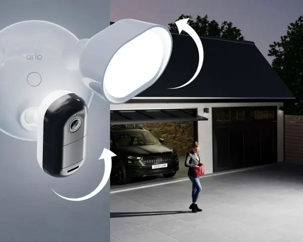 Arlo-kameran med lokal lagring lyser upp en uppfart där en kvinna närmar sig garaget med en bil.