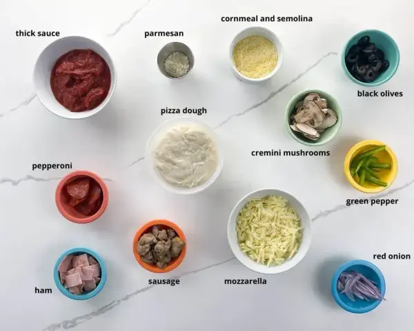 Składniki na pizzę: ciasto, sos, ser, salami, szynka, kiełbaski, pieczarki, oliwki, papryka, cebula i przyprawy. Idealne dodatki do pizzy!