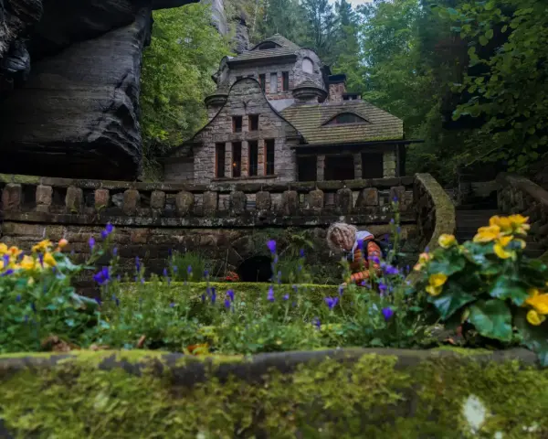 Kamienny domek w otoczeniu skał i zieleni, jak z bajki. To urokliwa Szwajcaria Czeska, gdzie natura splata się z architekturą.