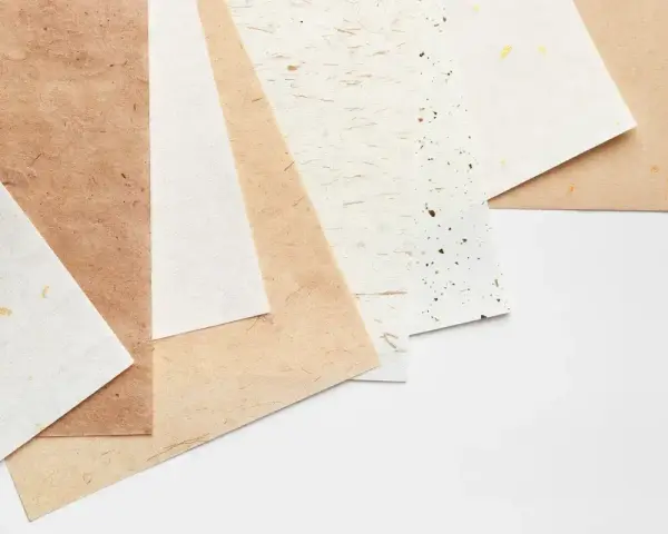 Różne rodzaje papieru, od jasnych po brązowe, z widoczną fakturą i złotymi drobinkami. Różna grubość papieru.