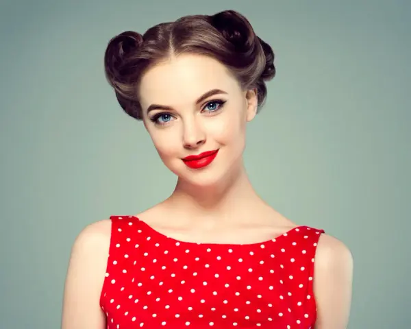Eleganckie fryzury retro na wesele, z kręconymi kokami i czerwoną sukienką w grochy.