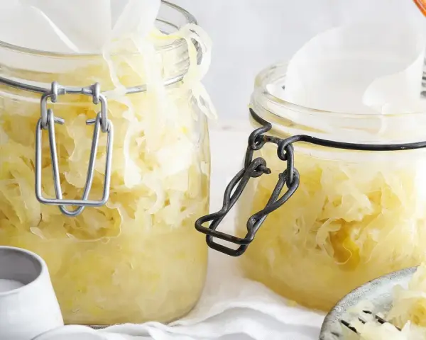 Zwei Gläser mit hausgemachtem Sauerkraut, bereit für die Fermentation. Ein einfaches Sauerkraut Rezept für gesunde Beilagen.