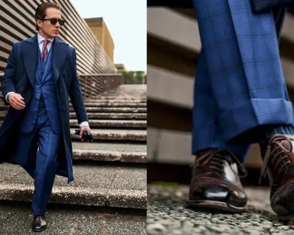 Un giovane uomo con un completo blu a quadri, cappotto scuro e occhiali da sole, cammina con passo sicuro. Un vero old money boy.
