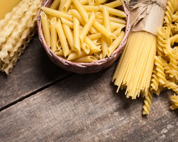 Różne rodzaje makaronu: penne, spaghetti, fusilli i faliste tagliatelle. Wybór między makaronem grahan a durum zależy od preferencji.