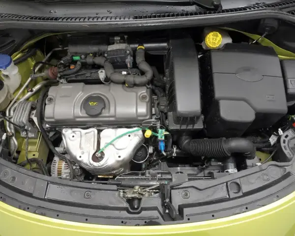 Silnik Peugeot 207, widok z góry. Widać elementy układu dolotowego, pokrywę zaworów i alternator.