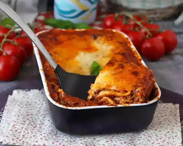 Gorąca, zapiekana lasagne bolognese z sosem pomidorowym i serem, gotowa do podania.
