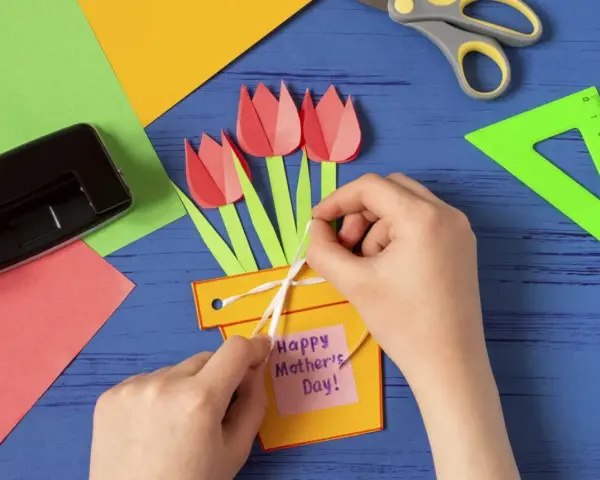 Dziecko tworzy kartkę z tulipanami i napisem "Happy Mother's Day!". To piękne prezenty robione przez dzieci.