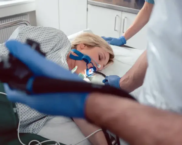 Pacjentka poddana endoskopii w celu diagnozy eozynofilowego zapalenia przełyku. Lekarz wprowadza endoskop.