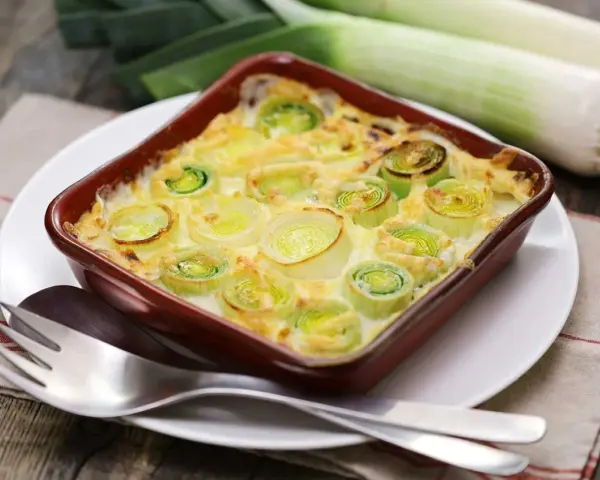 Puerros al horno gratinados, tiernos y dorados, listos para disfrutar.