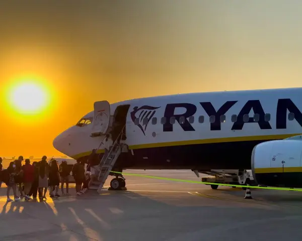 Ryanair loty za 1 zł – pasażerowie wsiadają do samolotu o zachodzie słońca.