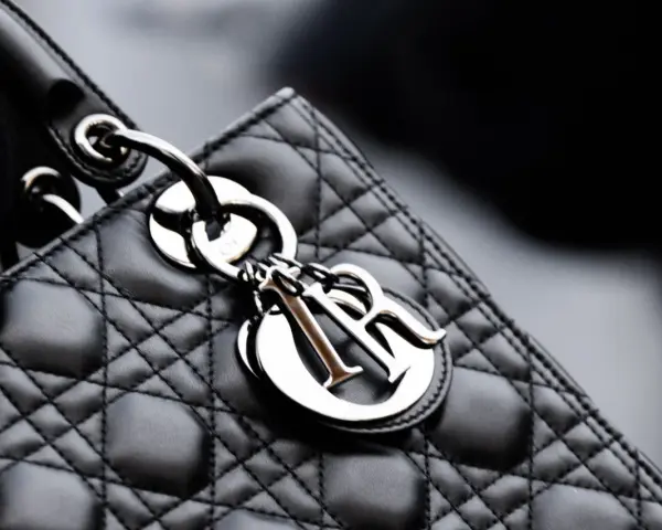 Elegancka, pikowana torebka Lady Dior w kolorze czarnym, z metalicznym logo Dior.