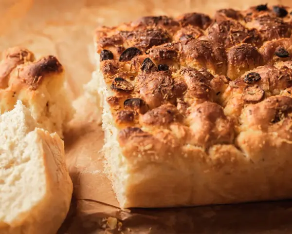 Puszysta focaccia z oliwkami i rozmarynem, idealna do podania. Ten przepis na focaccię jest prosty i szybki.