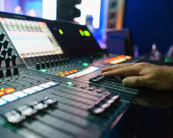 Hand bedient Mischpult für professionelles music management. Lichter und Regler zeigen die komplexe Steuerung.