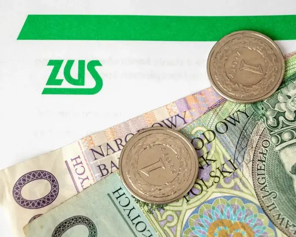 ZUS i polskie złotówki. Kiedy będzie 300 plus? Pieniądze i monety na tle dokumentu ZUS.