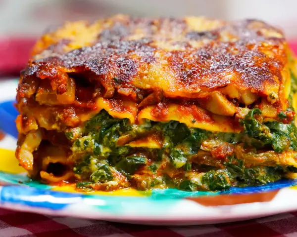 Deliciosa lasaña de verduras, con capas de pasta, espinacas y salsa de tomate, gratinada y dorada.