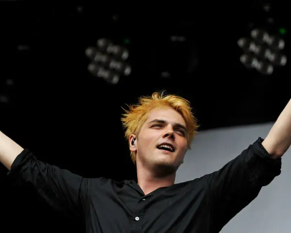 Gerard Way, Sänger des Musikgenres mit E, mit blonden Haaren und erhobenen Armen auf der Bühne.
