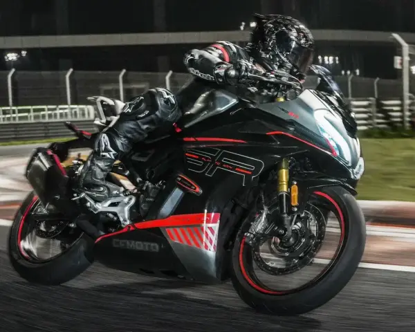 Un pilota in tuta nera sfreccia in pista con la CF Moto 450 SR, puntando alla velocità massima.