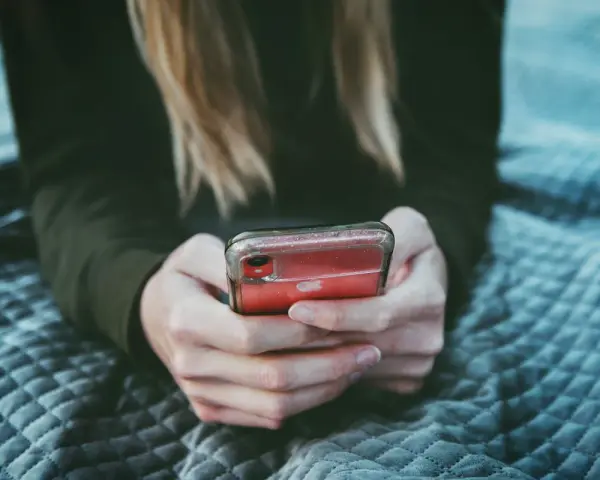 Dziewczyna przegląda profile na Tinderze, szukając dopasowania.