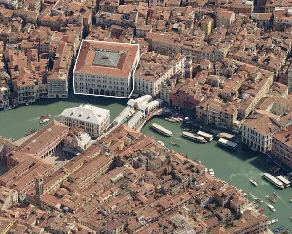 Vista aerea di Venezia, evidenziato il Fondaco dei Tedeschi, un imponente edificio storico affacciato sul Canal Grande, vicino al Ponte di Rialto.