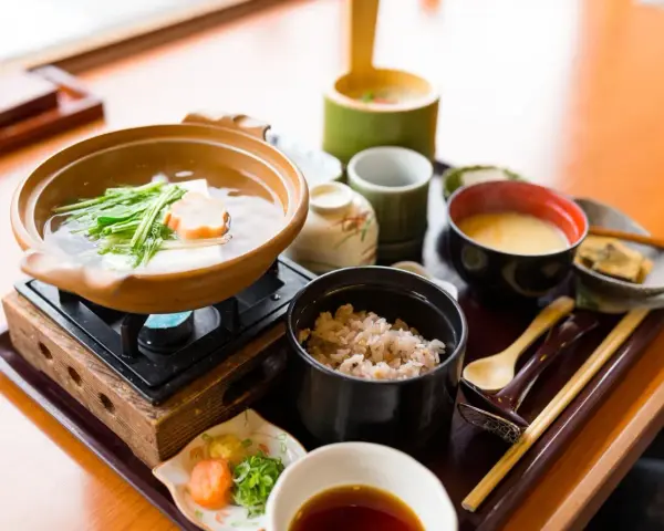 Japońskie śniadanie: gorący bulion z warzywami i tofu, ryż, zupa miso i dodatki.