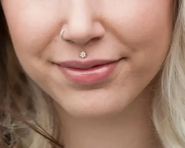 Delikatny piercing ust w kształcie kwiatka, ozdoba twarzy. Dowiedz się, co to piercing i jak podkreśla urodę.