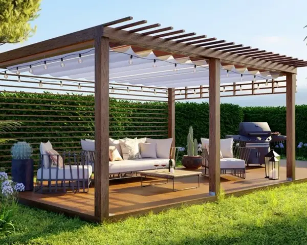 Pergola de madera con muebles cómodos, parrilla y luces, ideal para disfrutar del exterior.