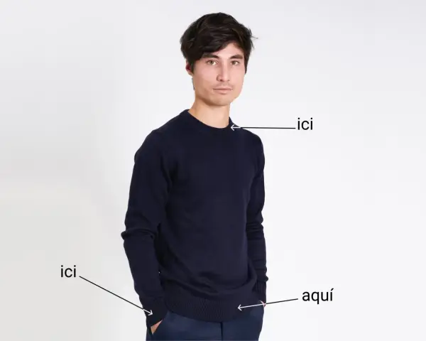 Un homme porte un pull bleu marine. Le tissu pul endroit envers est visible sur le bord du pull.