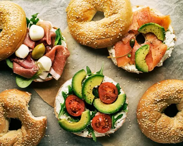 Pyszne bajgle z łososiem, awokado, pomidorami, szynką i mozzarellą – idealne co zamiast chleba na śniadanie czy lunch.