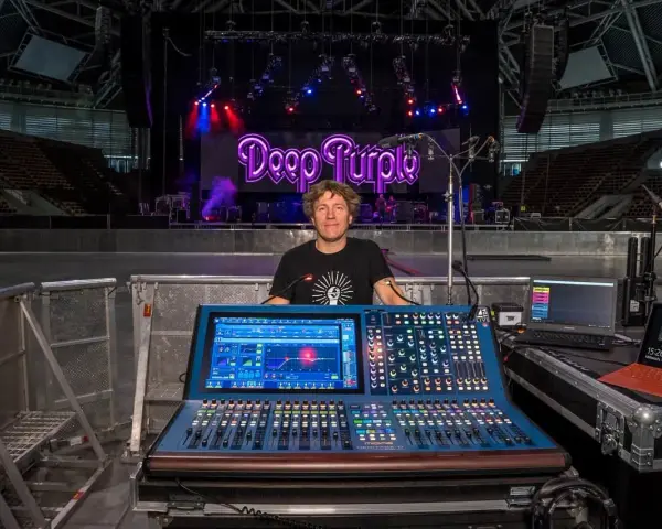 Mężczyzna przy konsolecie Midas, gotowy do obsługi koncertu Deep Purple. Dziedzictwo dźwięku na żywo.