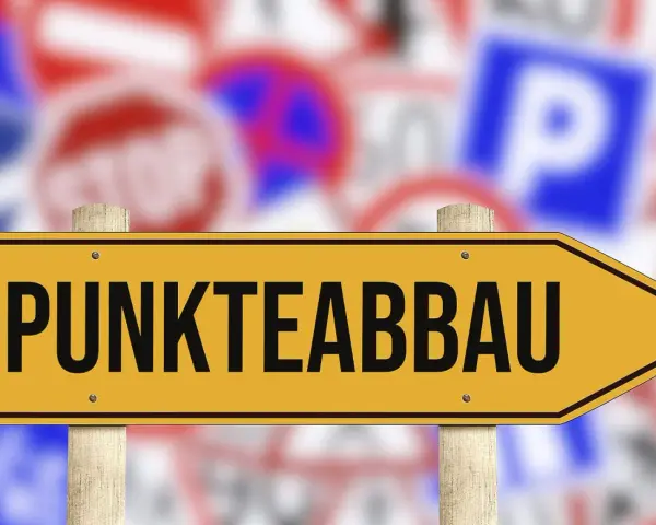 Gelbes Schild mit der Aufschrift "PUNKTEABBAU" weist den Weg. Informieren Sie sich über die fahreignungsseminar kosten, um Punkte abzubauen.