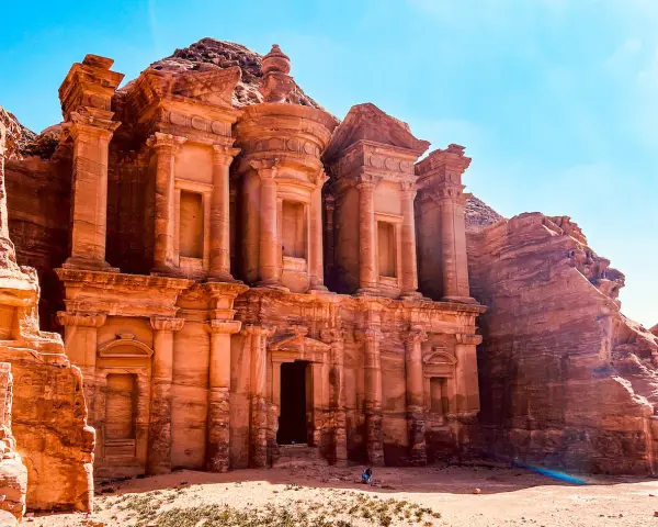 Le Monastère d'Ad-Deir, un trésor de Petra en Jordanie, se dresse majestueusement sculpté dans la roche ocre sous un ciel bleu éclatant.