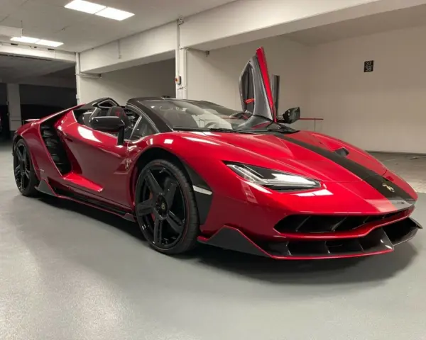 Czerwony kabriolet Lamborghini Centenario z otwartymi drzwiami typu nożycowego.
