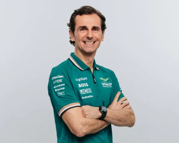Pedro de la Rosa, con brazos cruzados, sonríe con confianza. Viste un polo verde del equipo Aston Martin Aramco.