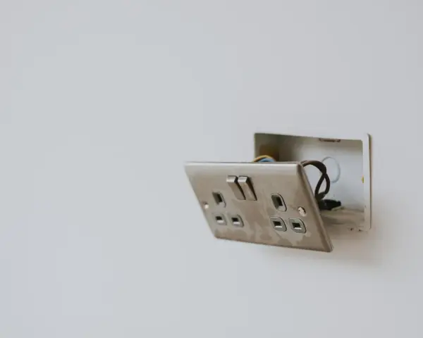 Enchufe con interruptor abierto, mostrando cables. Guía visual para como conectar un enchufe interruptor y bombilla.
