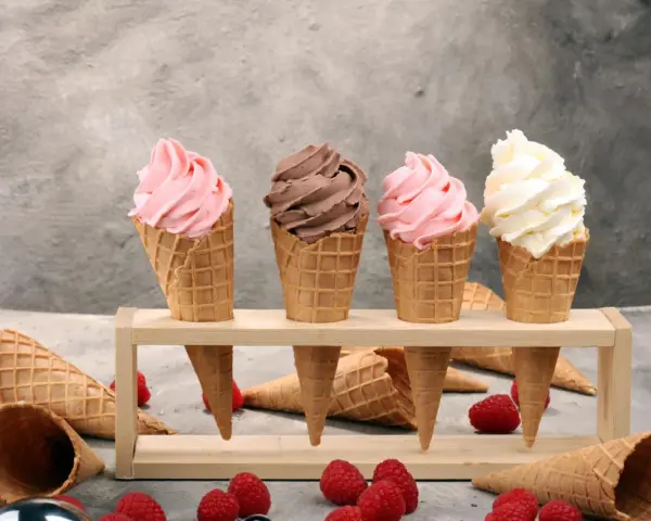 Vier Eiswaffeln mit Erdbeer-, Schoko- und Vanilleeis. Ein köstliches Gelato Rezept zum Nachmachen, mit frischen Himbeeren und Schokolade.