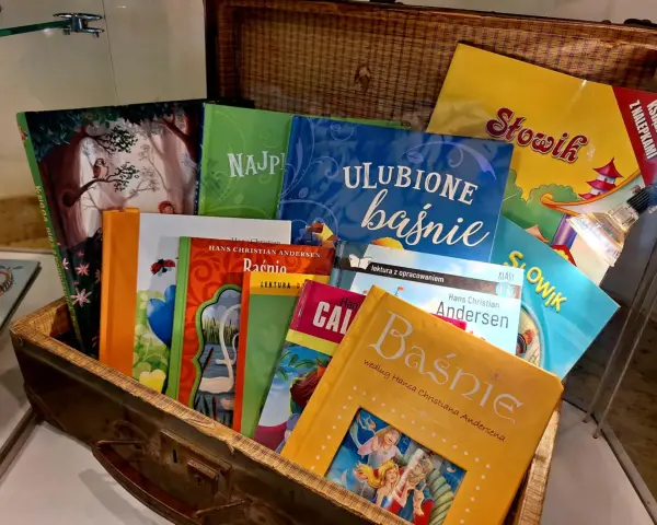 Książki z baśniami Andersena ułożone w kufrze. Wśród nich "Najpiękniejsze baśnie", "Ulubione baśnie" i "Słowik".