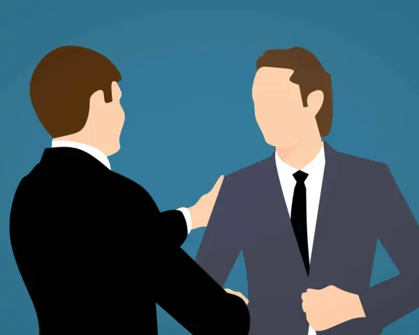 Deux hommes en costume se serrent la main, symbolisant un accord mutuel pour comment négocier une rupture conventionnelle.