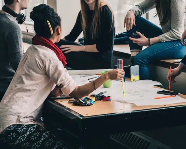 Groupe d'étudiants en formation uc direction bpjeps, travaillant sur un projet créatif avec des feutres et des schémas.