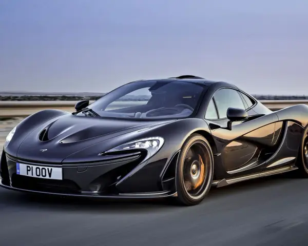 Czarny McLaren P1 w ruchu, z widocznym numerem rejestracyjnym PI 00V. Jego cena jest astronomiczna, ale wygląd zapiera dech.